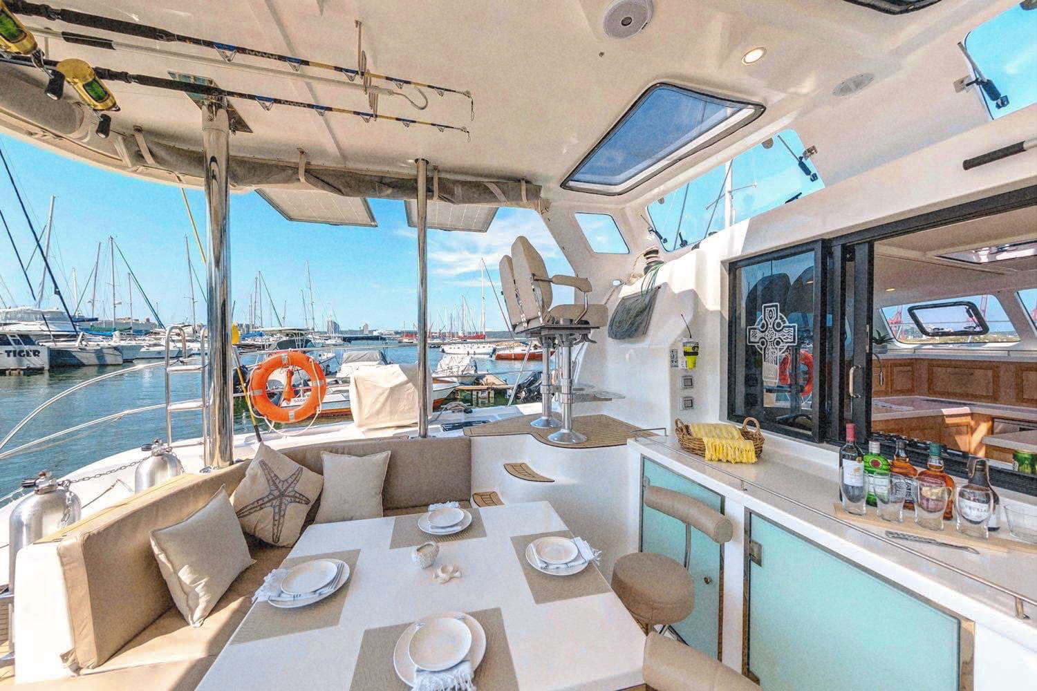 The shaded cockpit set for a meal, with the marina beyond