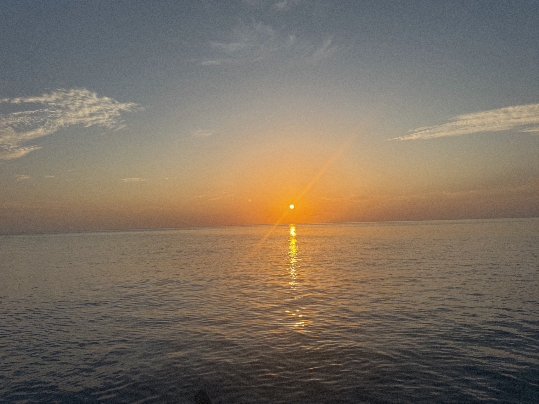 The sun setting over calm water