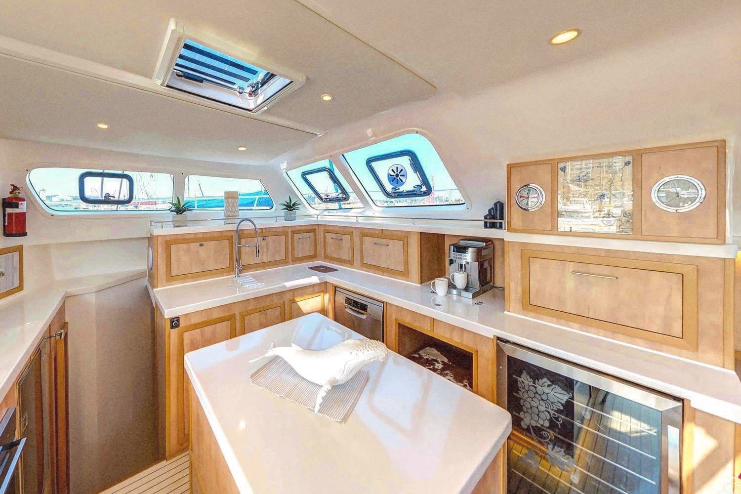 The bright galley with warm wooden cabinets, skylights and sea views