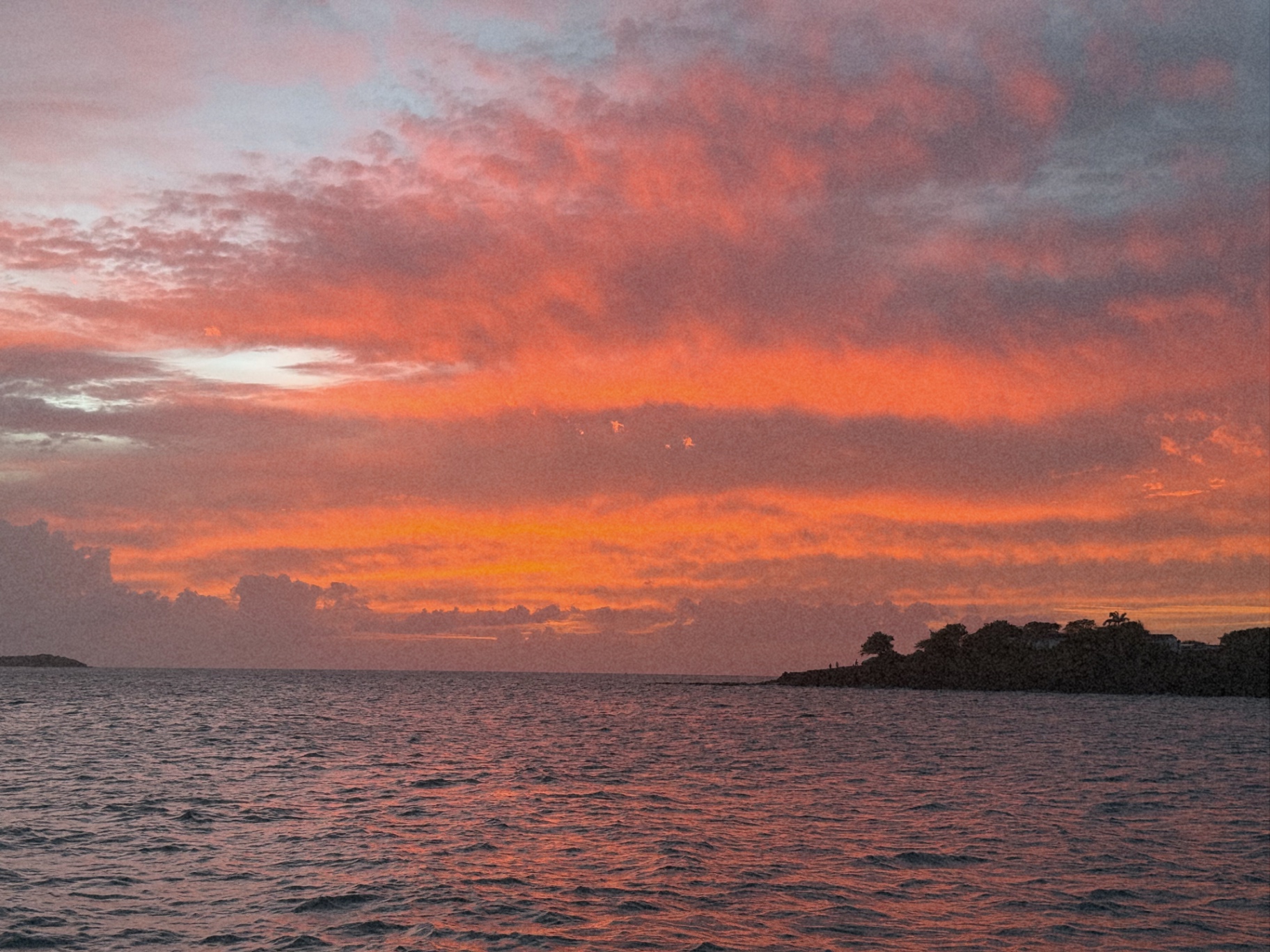 A pink and orange sunset sky over the sea